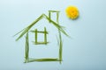 house made of grass bades with chimney and a dandelion as the sun. Royalty Free Stock Photo