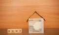 House made from the Indian currency notes and Home Loan in wooden block letters on wooden background Royalty Free Stock Photo