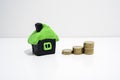 House made from plasticine and some coins near it. Royalty Free Stock Photo