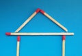 A house of matchsticks over blue background.