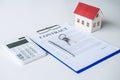 House model, calculator and house key lying on real estate contract, home loan and investment concept Royalty Free Stock Photo