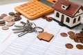 House model with calculator, keys and coins on documents. Real estate agent service Royalty Free Stock Photo