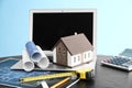 House model with drawings and laptop on table. Mortgage concept Royalty Free Stock Photo