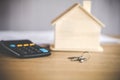 House model keys and calculator on desk , planning to buy or selll home