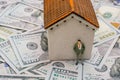 House model and a man figurine on US dollar banknote background Royalty Free Stock Photo