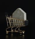 House model in mini shopping cart on the black background. Buy a house. Concept for property ladder, mortgage and real Royalty Free Stock Photo