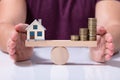 House Model And Money Coins Balancing On A Seesaw Royalty Free Stock Photo