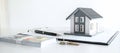 House model and Money, house key lying on real estate contract, home loan and investment concept Royalty Free Stock Photo