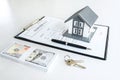 House model and Money, house key lying on real estate contract, home loan and investment concept Royalty Free Stock Photo
