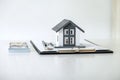 House model and Money, house key lying on real estate contract, home loan and investment concept Royalty Free Stock Photo