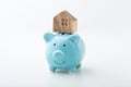 House model on piggy bank on white background Royalty Free Stock Photo