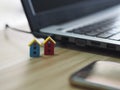 House model plastic color red and blue, mini object on wooden table, Blurred of notebook and mobile phone background Royalty Free Stock Photo