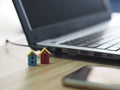 House model plastic color red and blue, mini object on wooden table, Blurred of notebook and mobile phone background Royalty Free Stock Photo