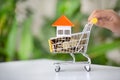 House and money coin in shopping cart,  Buying and selling real estate. Property investment and house mortgage financial concept Royalty Free Stock Photo