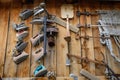 House-museum with old items from traditional rustic life. Vintage irons on the wooden wall, close up. Abstract retro image for the