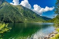 House near green clear lake with rocks and trees in the mountains Royalty Free Stock Photo