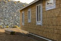 House nearing completion of construction. Stack of boards in the dirt ready for building