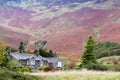 House nestling against a background of a steep fell side Royalty Free Stock Photo