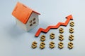 House next to dollar signs and a growing arrow. Increasing the value of real estate concept. Royalty Free Stock Photo