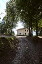 House next to a gravel road on the ridge of a mountain framed by trees Royalty Free Stock Photo