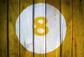 House number or calendar date in white circle on yellow toned Royalty Free Stock Photo