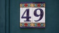 House number forty-ine 49 painted on ceramic tile in blue and yellow, red and gold from Israel