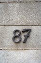 House number numerals on a concrete wall. Number 87 decorative types, close up, no people Royalty Free Stock Photo