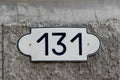 House number 131 one hundred and thirty one. Black lettering on a white fashioned metal plate