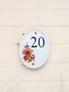 house number plate on outside white wall number 20 flower design Royalty Free Stock Photo