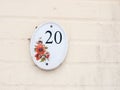 house number plate on outside white wall number 20 flower design Royalty Free Stock Photo