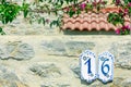 House number sixteen on stone wall in the street. Royalty Free Stock Photo