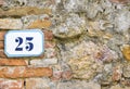 A house number twentyfive (25) on a wall in Pienza, Tuscany