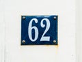 House number 62 white numbers on blue shield