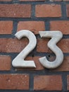 House number 23, white numbers on a clinker wall Royalty Free Stock Photo