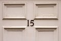 House number 15 on a white square panelled wooden front door in Britain