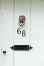 The house number 68 on a white wooden door