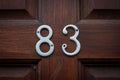 House number 83 on a wooden front door Royalty Free Stock Photo