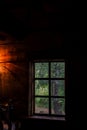 The house is old in the forest. Mysterious mystical fairy light lamp in the scary darkness of the room and a view through the