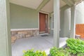 House with an open porch and brown wooden front door with one glass sidelight Royalty Free Stock Photo