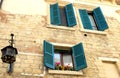 House with open windows and flowers near the cathedral of Verona Royalty Free Stock Photo