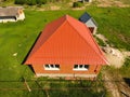 House with an orange roof made of metal, top view. Metallic profile painted corrugated on the roof. Royalty Free Stock Photo