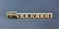 In-house or outsourced service symbol. Turned wooden cubes and changed words In-house service to Outsourced service. Grey