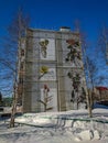 The house is painted with graffiti. Urban northern panel house on the background of birches. Russia