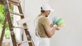 House painter man decorator choose the color using the sample swatch, work the white wall of the house to renovate, a wooden