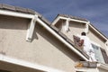 House Painter Painting the Trim And Shutters of Home