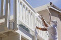 House Painter Spray Painting A Deck of A Home Royalty Free Stock Photo