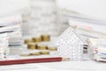 House and pencil with blur coins between overload of paperwork Royalty Free Stock Photo