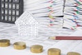 House and pencil have blur pile gold coins as foreground Royalty Free Stock Photo