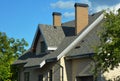 A house with a pitched roofing construction with asphalt shingles installed, attic windows, skylights, soffit and fascia boards, Royalty Free Stock Photo