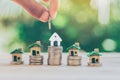 House placed on coins. hand that is coin down the house.